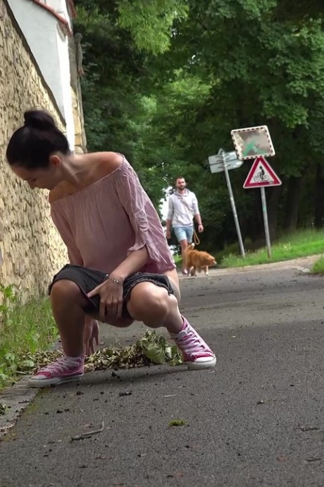 Коротко снятая девушка Мистика садится на корточки, чтобы пописать, на мощеной дорожке в городской обстановке 2