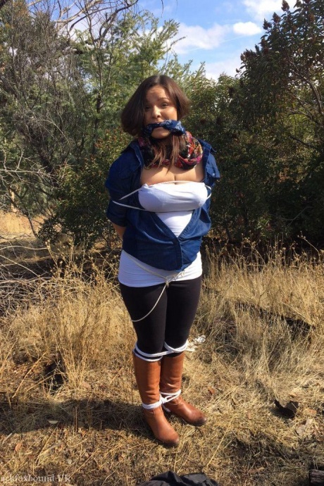 Полностью одетый толстяк расколот, с кляпом во рту и связанный веревкой в заросшем кустарником лесу 5