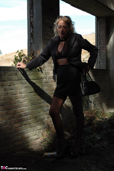 Зрелая блондинка Кирас Нейлонс позирует на шпильках в чулочно-носочных изделиях и черной юбке 5