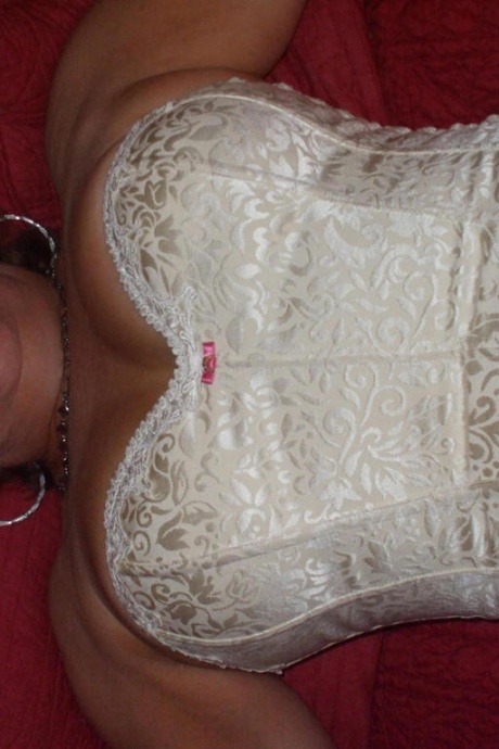 Зрелая женщина позирует обнаженной в корсете и нейлоновых чулках с подвязками 17