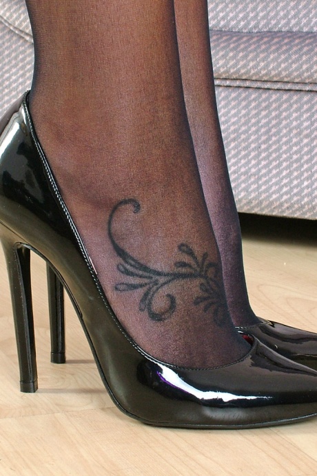 Знойная шлюха в короткой юбке демонстрирует свои длинные ноги в черных чулках и на каблуках 14