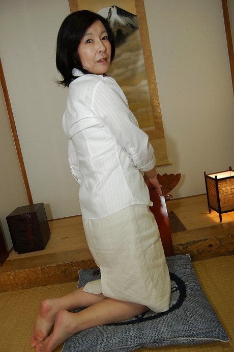 Озорная зрелая азиатка раздевается догола и обнажает свою лохматую киску 3