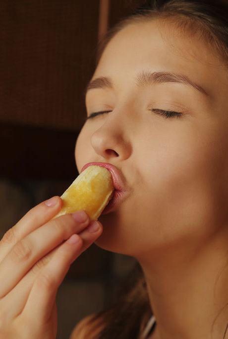 Красивая девушка-подросток показывает свои большие сиськи и лысую пизду, поедая фрукты 6