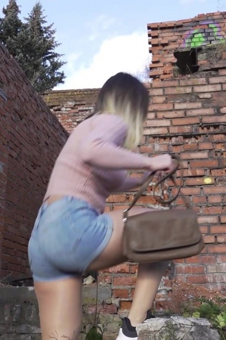 Белая девушка прячется за старым зданием, чтобы срочно отлить 2