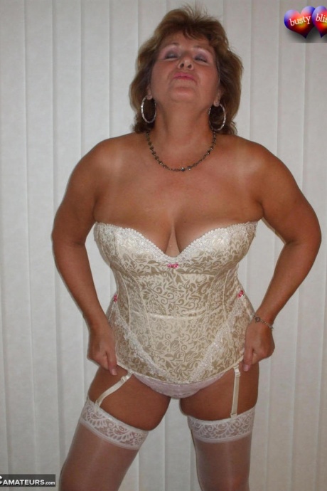 Зрелая женщина позирует обнаженной в корсете и нейлоновых чулках с подвязками 3