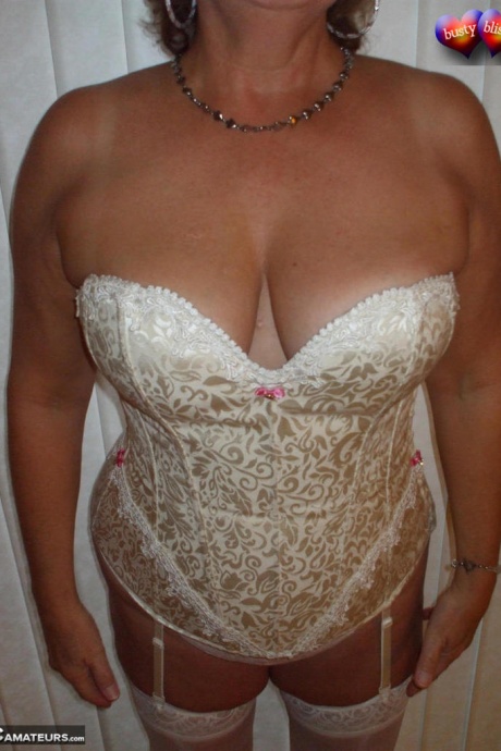 Зрелая женщина позирует обнаженной в корсете и нейлоновых чулках с подвязками 13