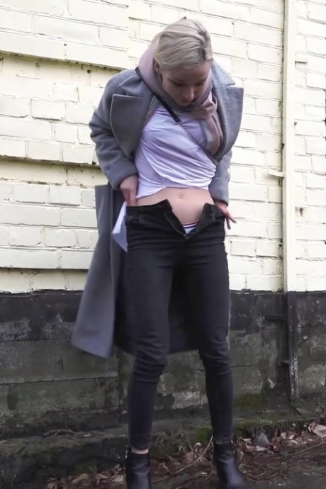 Белокурая девушка Маша стягивает штаны, чтобы пописать на тротуаре в дождливый день 2