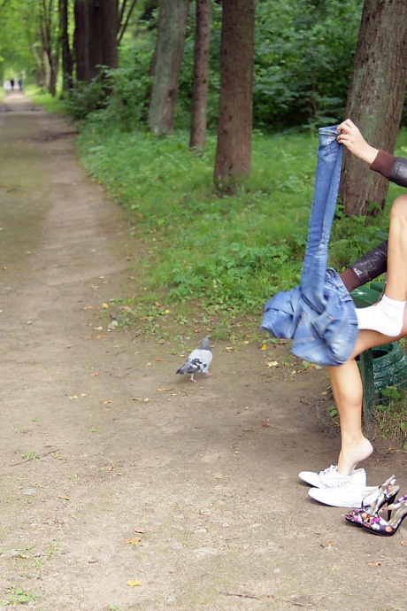 Симпатичная девушка со светлыми волосами Летний бриз показывает свое обнаженное тело на скамейке в парке 2