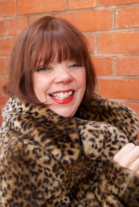 Рыжеволосая девушка постарше мелькает в пальто с леопардовым принтом и черных чулках 15