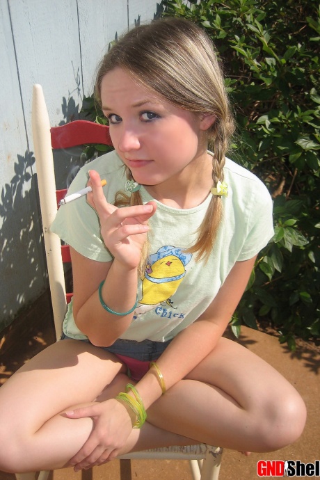 Молодая девушка курит сигарету, обнажая свои сиськи и киску 5